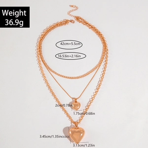 Layered gold heart pendant necklace with multi-row aluminum chain and metallic toggle clasp