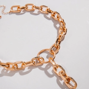 Close-up of chunky gold layered aluminum chain necklace with polished oval geometric links