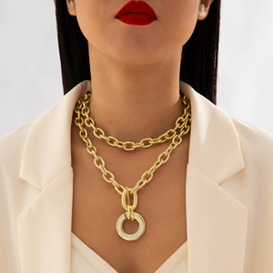 Double-layered gold chunky chain necklace with large ring pendant on white blazer