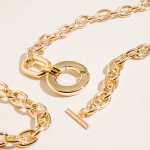 Detailed view of chunky gold aluminum chain links with classic OT toggle clasp design