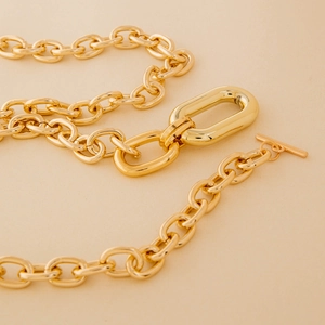 Detailed macro view of high-gloss gold chain link necklace with stylish OT toggle closure