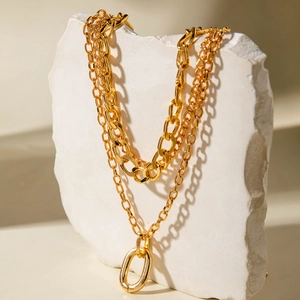 Detail view of gold layered chunky chain necklace with large oval ring on stone