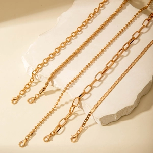 Detailed view of layered gold-plated aluminum chains with various links and lobster clasps