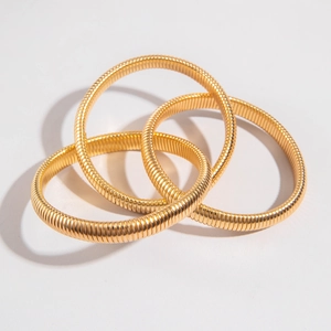 Three-piece set of gold snake-bone textured stretch bracelets with a high-shine metal finish