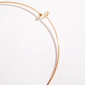 Minimalist gold metal choker necklace featuring a unique spherical buckle closure design