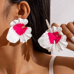 Close-up of model wearing large white and pink floral petal stud earrings in enamel finish