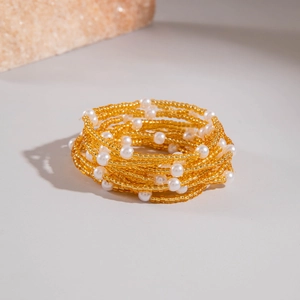 Ensemble de douze bracelets superposés avec perles dorées et perles d'imitation blanches