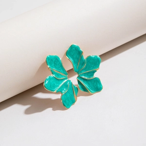 Close-up of cyan enamel petal earring with golden edges and textured floral surface