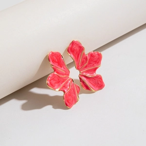 Detailed macro shot of vibrant pink enamel flower earrings with golden metallic edges