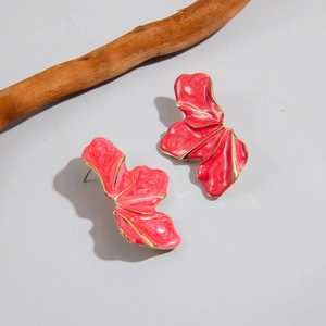 Detailed macro view of dark pink enamel flower earrings with gold metallic edges