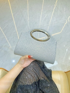 Detailed shot of silver sequined evening clutch with sleek oval metal handle design