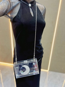 Dettaglio pochette in acrilico con decoro luna in strass e tracolla a catena
