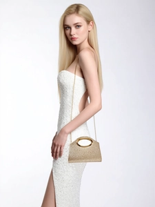 Detail of gold sequin evening clutch with metallic ring handle and fine chain strap