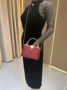 Deep magenta luxury clutch with snake texture, gold bamboo handle and leaf clasp detail