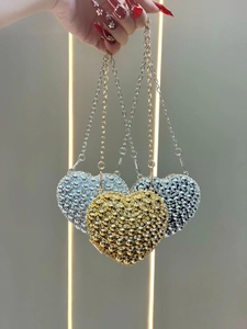 Detail of luxury heart-shaped mini bags with sparkling rhinestones and metal chain straps