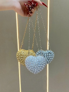 Detailed view of heart-shaped rhinestone evening bags in gold, silver and black-silver
