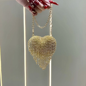 Detail of a heart-shaped evening bag with gold rhinestones and tassel chain decoration