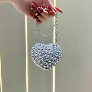 Detailed view of handmade heart-shaped silver rhinestone evening bag with chain strap