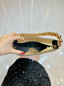 Elegant gold beaded handbag with large metallic handle and crossbody chain for formal gala