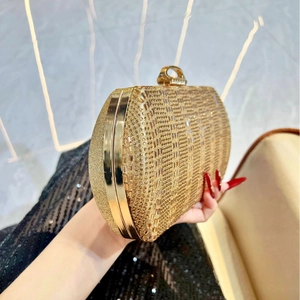 Détail de la pochette de soirée dorée avec strass et fermoir en forme de bague cristal