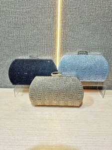 Vue détaillée des pochettes de soirée en strass scintillants bleu marine, bleu clair et or