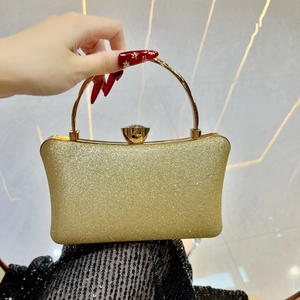 Macro shot of gold evening clutch featuring sparkling sequins and a gemstone clasp