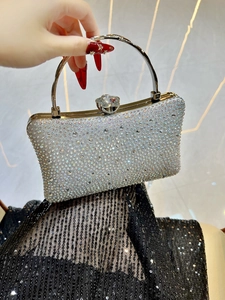 Close-up of sparkling silver rhinestone evening clutch with crystal floral metal handle