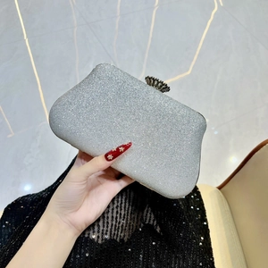 Dettaglio di una pochette da sera glitterata argento con chiusura a fiore in metallo