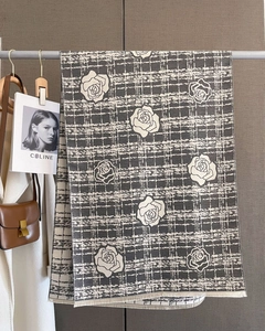 Detail of camellia floral pattern and fringe edge on thick dark grey cashmere scarf