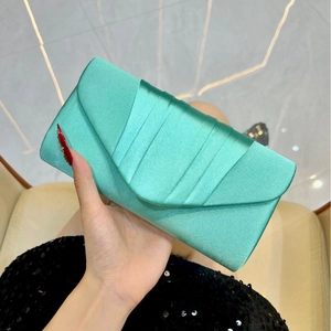 Detail of mint green pleated satin evening clutch bag with envelope flap and silk finish