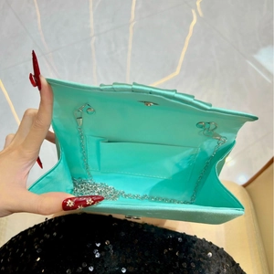 Detailed interior of mint green satin clutch showing inner pocket and silver chain strap