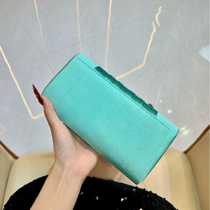 Detailed view of mint green pleated satin evening clutch bag with elegant chain strap