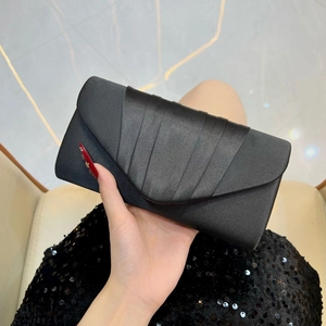 Macro detail of elegant pleated satin texture and folding craft on the black evening clutch
