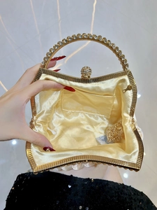 Macro view of gold evening clutch bag interior with yellow satin lining and metal chain