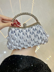 Detail of lavender satin pleated evening clutch with rhinestone handle and orb clasp