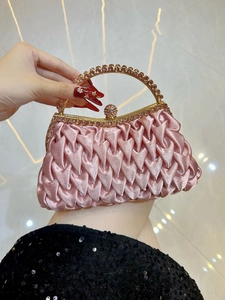 Detailed shot of pink pleated satin evening clutch with sparkling rhinestone handle