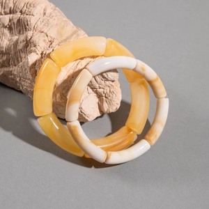 Minimalist acrylic two-tone stretch tube bead bracelets on natural stone background