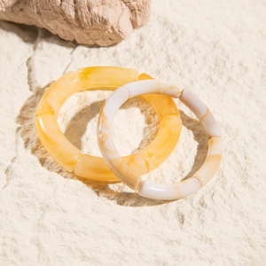 Two-piece set of acrylic bamboo-style tube bead bracelets with amber and marble textures