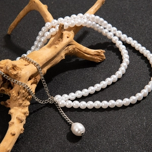 Détail d'une élégante chaîne de corps double rang en perles blanches et pendentif goutte