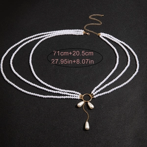 Détail de la chaîne de taille à trois rangs de perles avec anneau doré et pendentifs