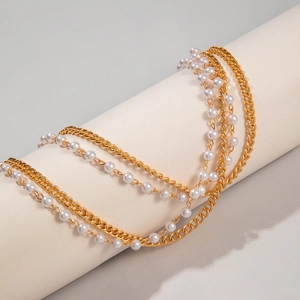 Détail de la chaîne de corps multicouche en or et perles blanches pour accessoire de taille