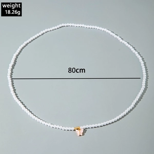 Detailed view of an 80cm white pearl body chain with a pink butterfly pendant weight 18.26g