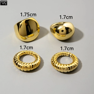 Dettaglio del set di 4 anelli geometrici dorati con superfici lisce e texture intrecciate
