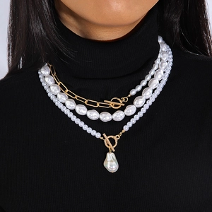 Détail d'un collier multicouche orné de perles baroques et d'un fermoir à bascule doré