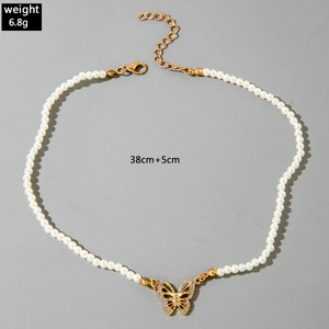 Détail du collier de perles avec pendentif papillon doré et fermoir à bascule OT ajustable