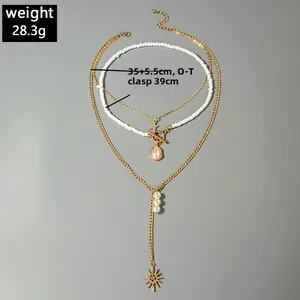 Vue détaillée d'un collier multicouche en perles dorées avec fermoir OT et pendentif étoile