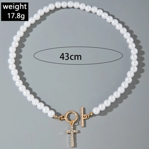 Détail du collier de perles multicouche avec fermoir OT doré et pendentif croix serti