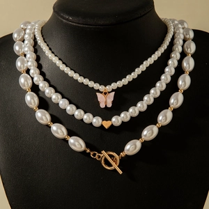 Détail du collier de perles multicouche avec pendentif cœur doré et fermoir à bascule