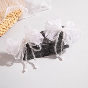 Détail de pinces à cheveux en organza blanc avec perles et franges en cristal