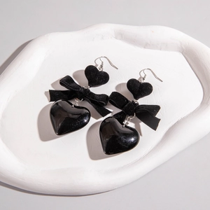 Retro black velvet bow and heart earrings on a stylish white decorative tray